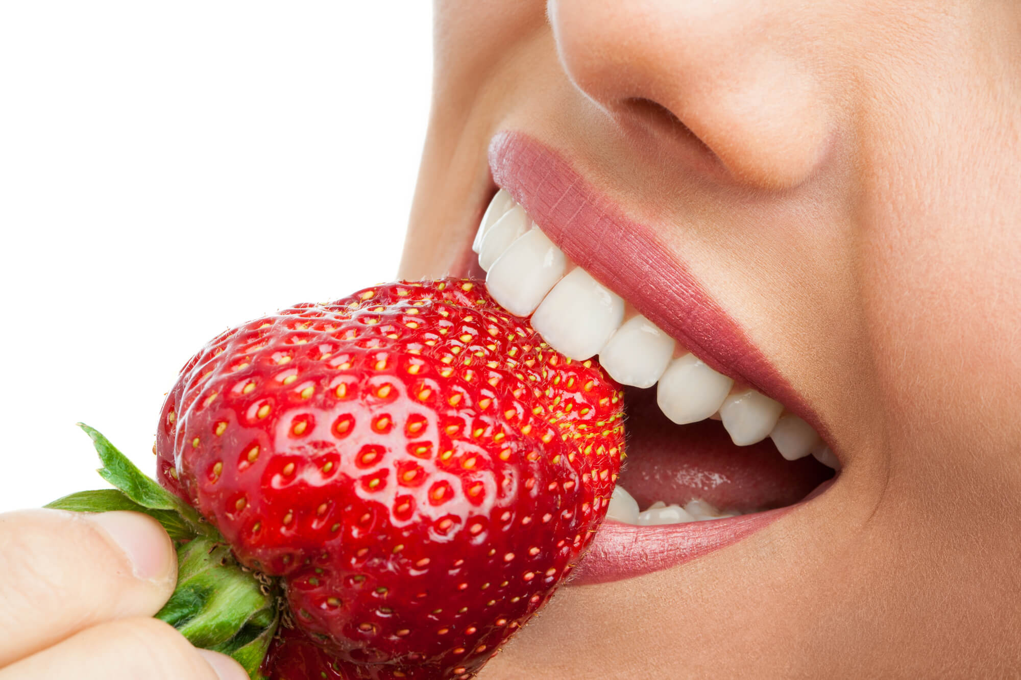 woman biting strawberry after cosmetic dentistry lake worth fl