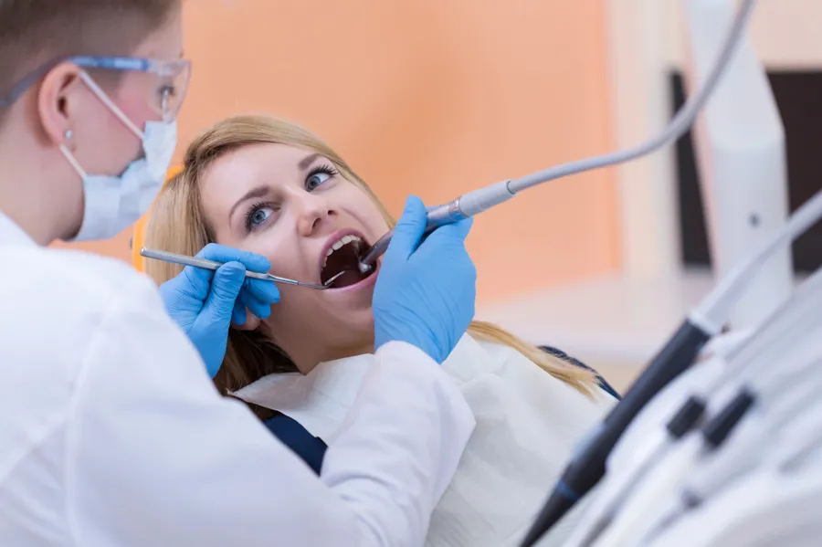 dentist performing root canal treatment female patient