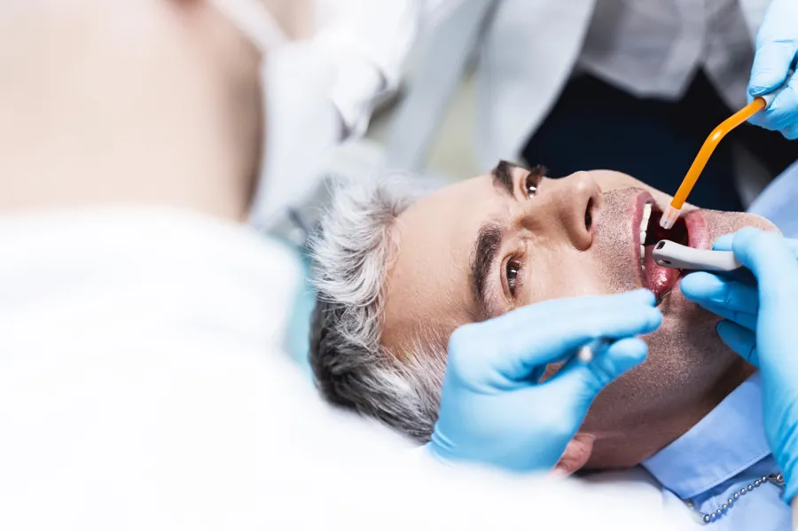 dentist performing root canal treatment male patient