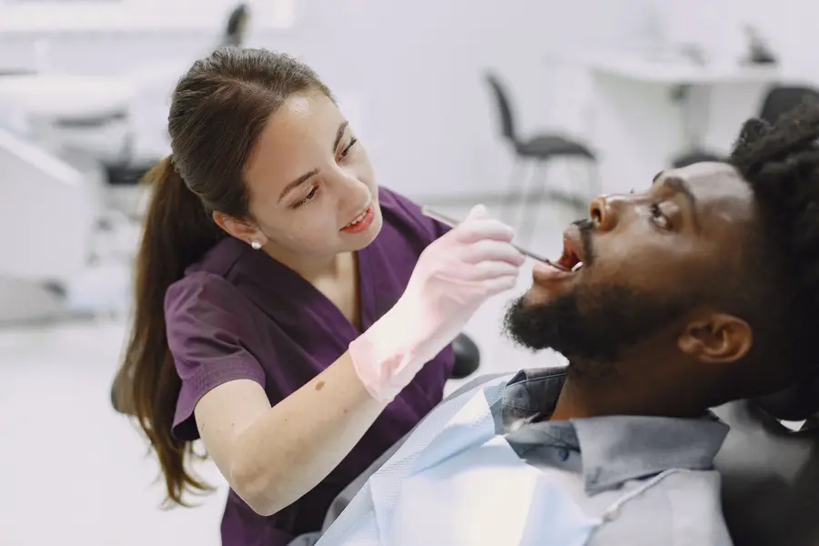dentist-in-lake-worth-fl-checking-bearded-mans-teeth-with-tool