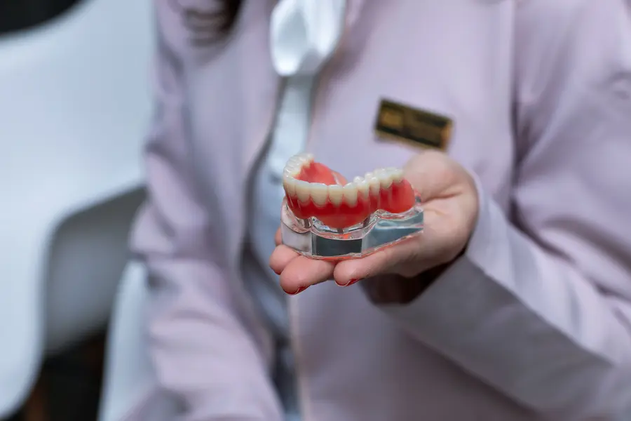 dentures-lake-worth-dentist-holding-implant-supported-denture-model